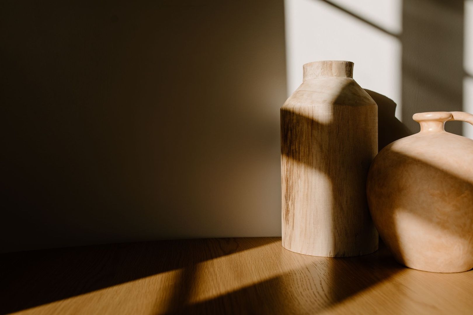 Två rustika träkärl i varmt solljus på ett träbord